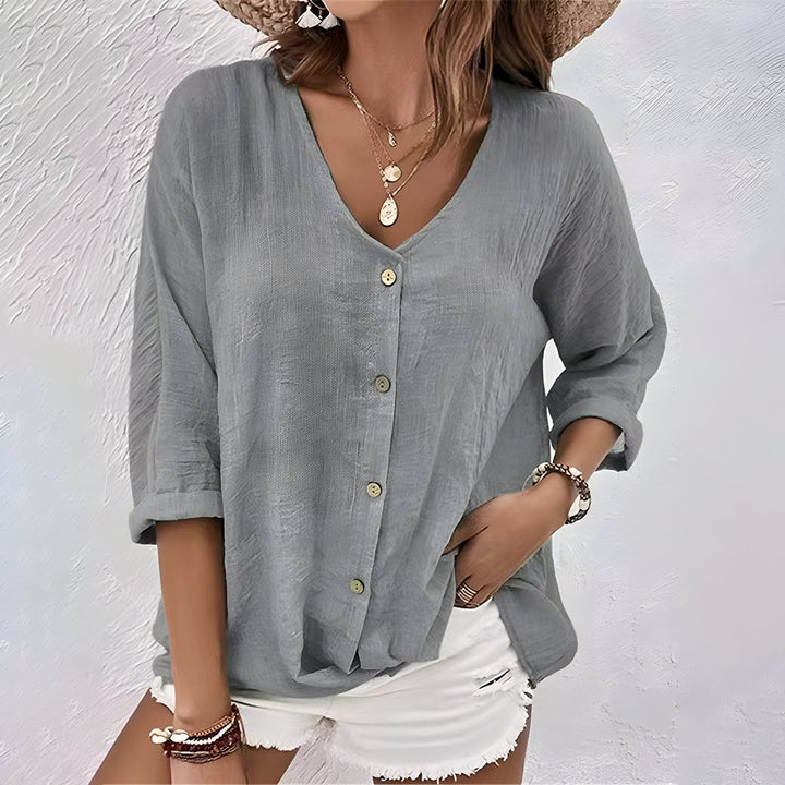 Side view of a women's relaxed fit button-up blouse showing roll sleeve detail