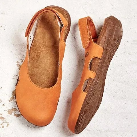 Overhead flat-lay of support sandals in black against a neutral background