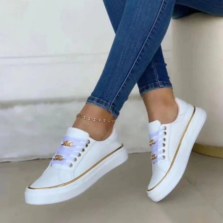 Black women's platform sneakers styled with casual outfit, showcasing gold chain detail and elevated platform sole