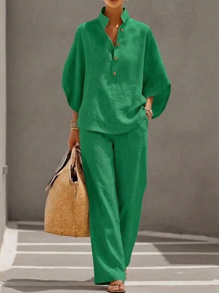 Side view of the Nadia wide-leg pants with elastic waist in navy, paired with the matching batwing top