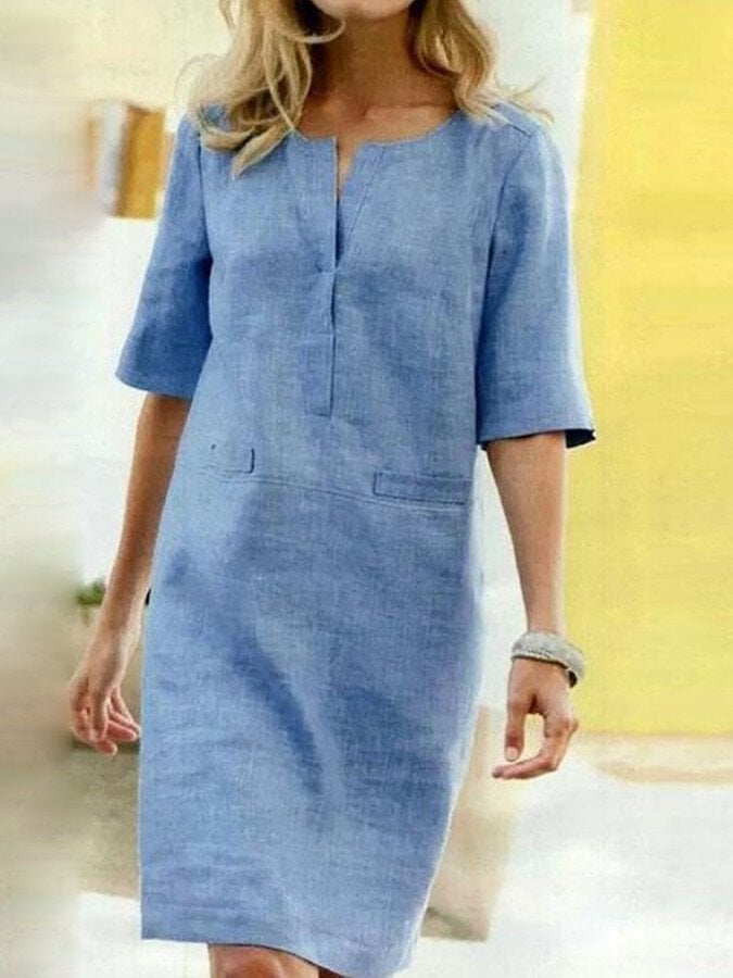 Woman wearing the Nora linen-look shift dress in Heaven Blue with a notched V-neckline and half sleeves, knee length