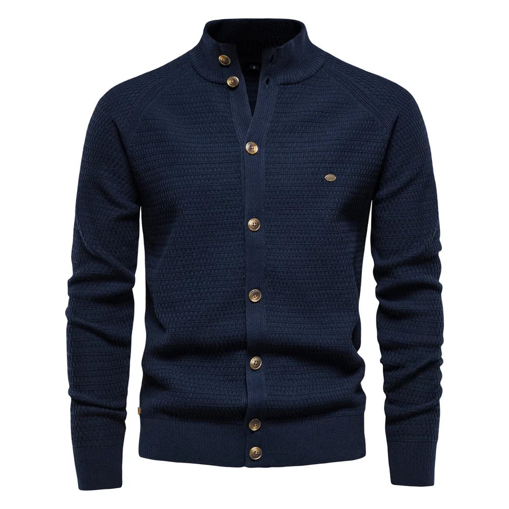 Full-length shot of model wearing the luxe cable-knit vest in navy blue paired with tailored trousers