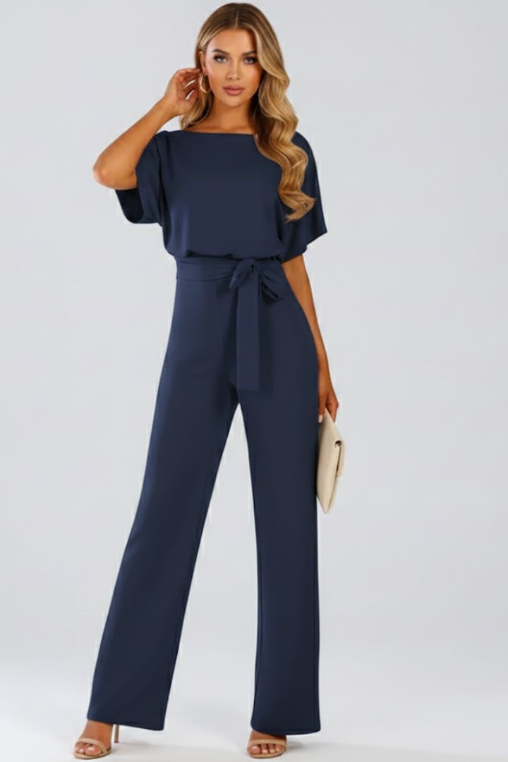 Woman in red wide leg short sleeve jumpsuit with tie belt, front view