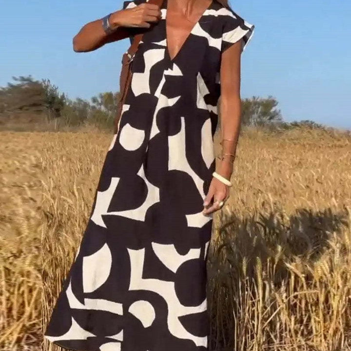 Woman wearing the Palmer flowy abstract print maxi dress in a bold color, full-length front view