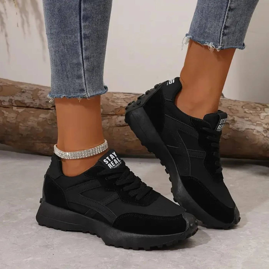 Reeve retro runner sneakers in black with mixed-texture upper and ridged outsole, front three-quarter view