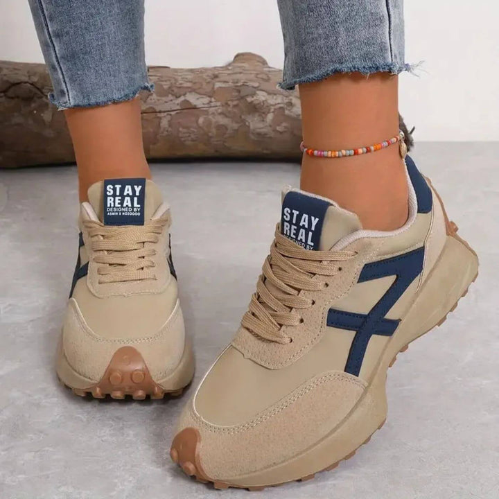Close-up of Reeve retro runner sneaker showing suede-effect panels and graphic side panel accent