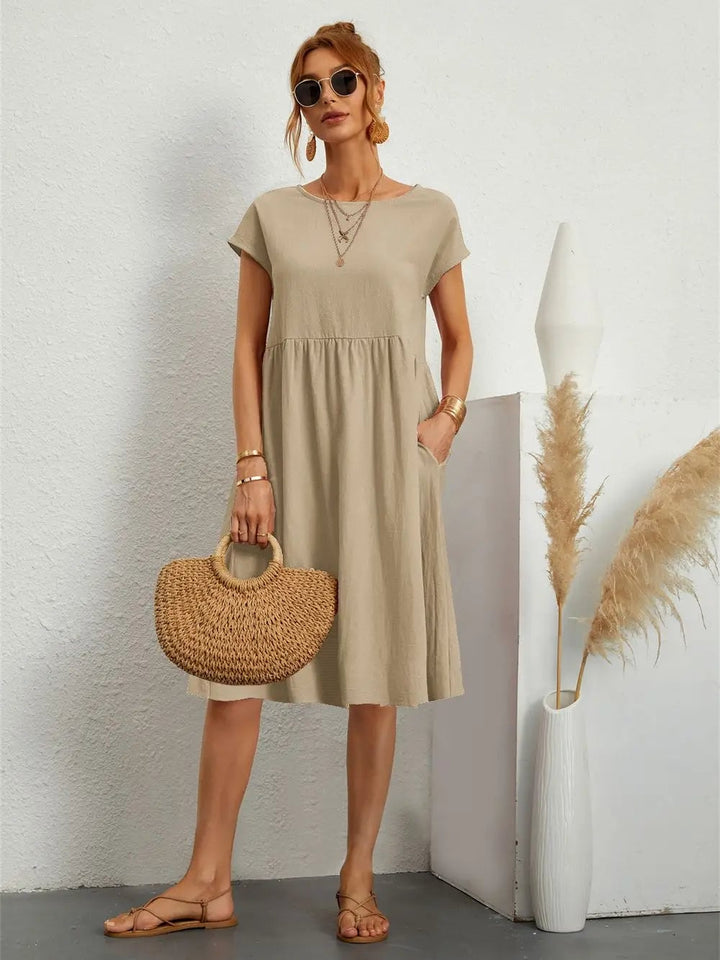 Full-length view of model in casual pocket dress, demonstrating the flattering relaxed silhouette and clean modern styling