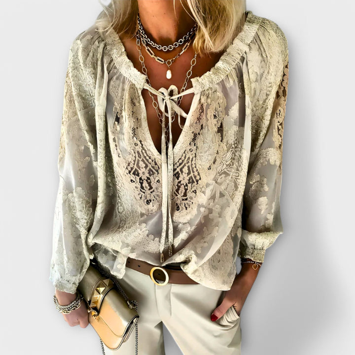 Rosalynn lace blouse styled with tailored trousers, shown from the side to highlight the V-neckline silhouette