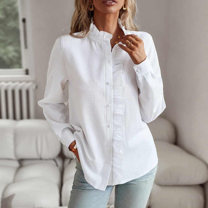 Woman in a white pleated long-sleeve blouse paired with high-waisted jeans for a casual look