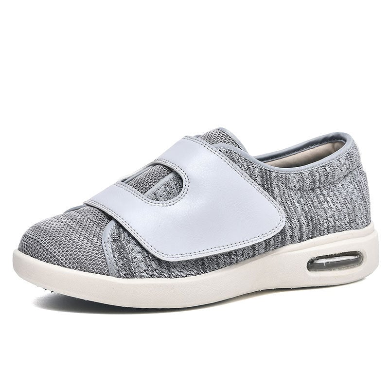 Women's wide fit slip-on walking sneaker with Velcro strap in gray, shown from a three-quarter front angle
