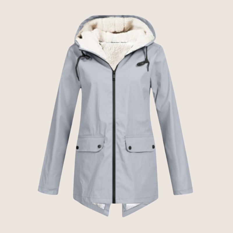 Woman in navy ThermaShell rain jacket walking outdoors in light rain, hood up
