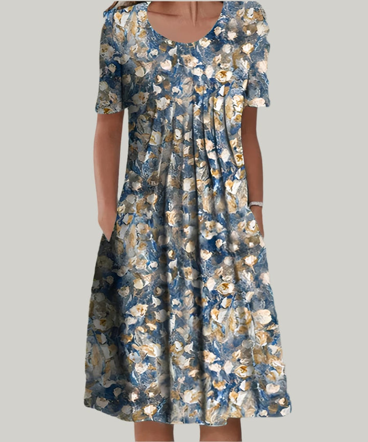 Woman styling the Tina elegant dress in White with Yellow print paired with sandals for a casual daytime look