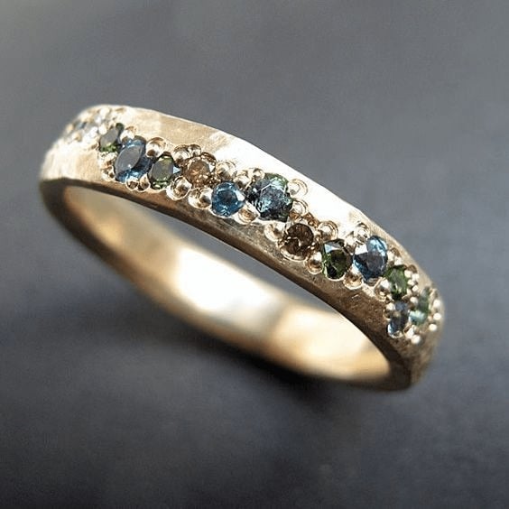 Vintage multicolor gold-tone statement ring with intricate detailing, shown close up against a neutral background