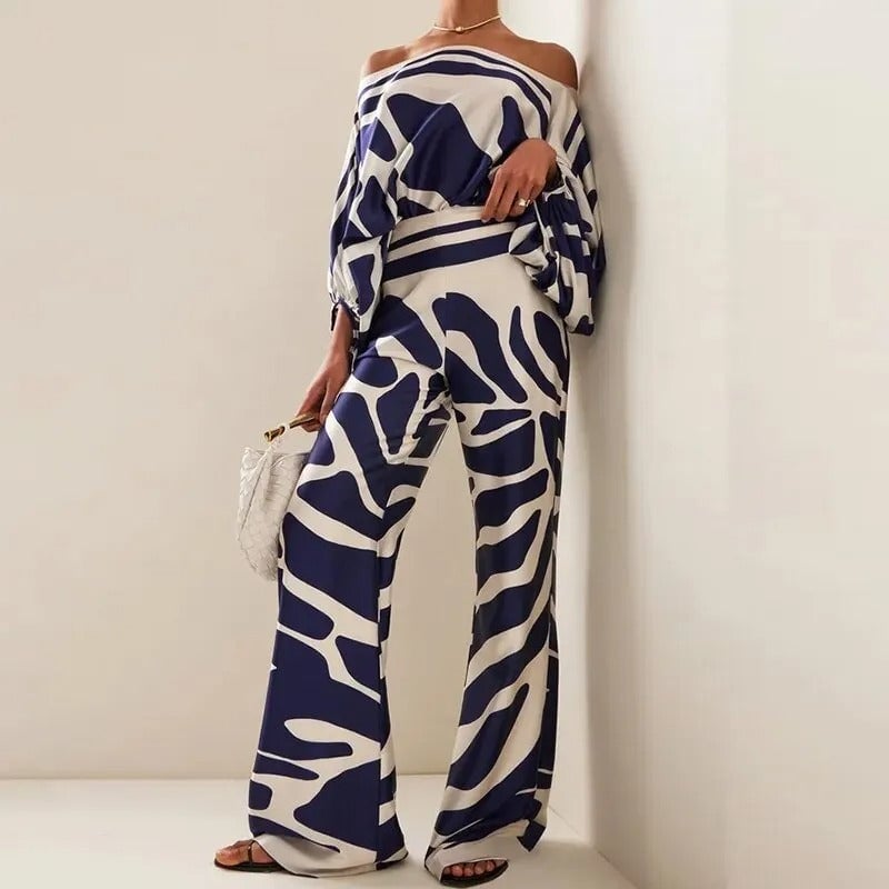 Woman wearing a navy and white abstract print off-shoulder batwing top and matching wide-leg pants from BobaFashion