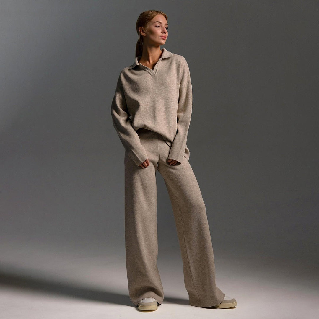 Woman wearing a soft knitted two-piece tracksuit set with wide-leg pants and a relaxed pullover top in a neutral color