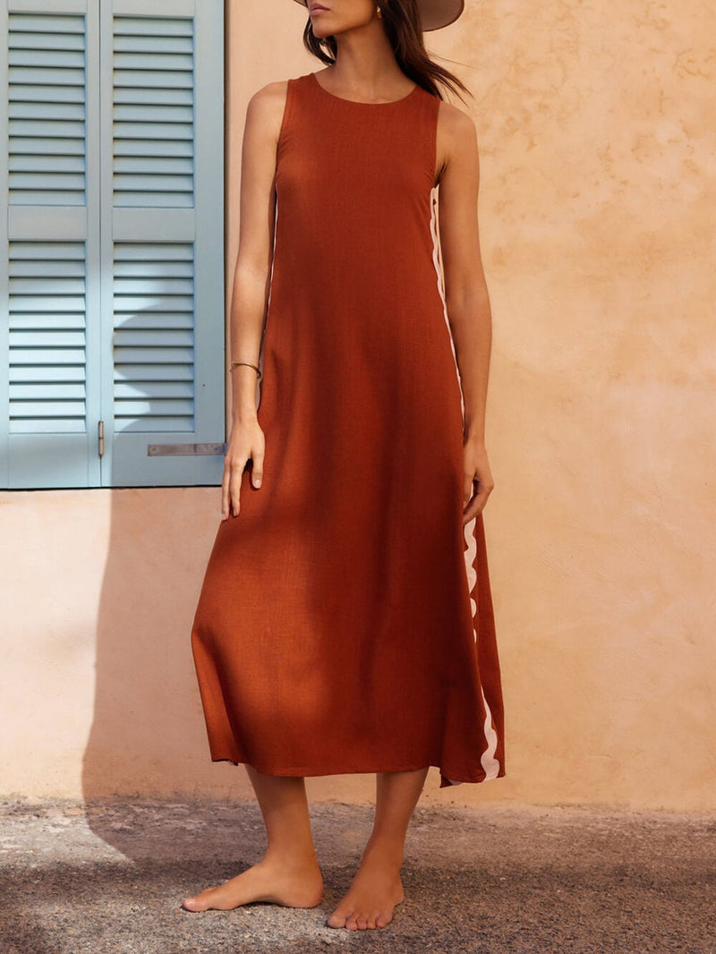 Side view of black sleeveless midi dress showing wavy ric-rac trim detail and subtle side slit hem