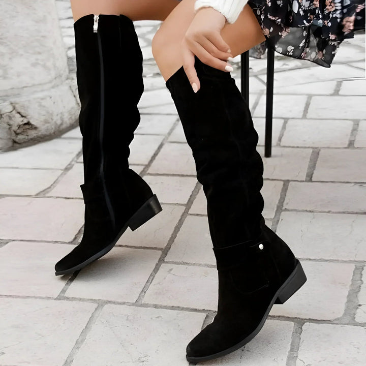 Lifestyle shot of women's suede knee-high boots in dark green styled for a fall outfit